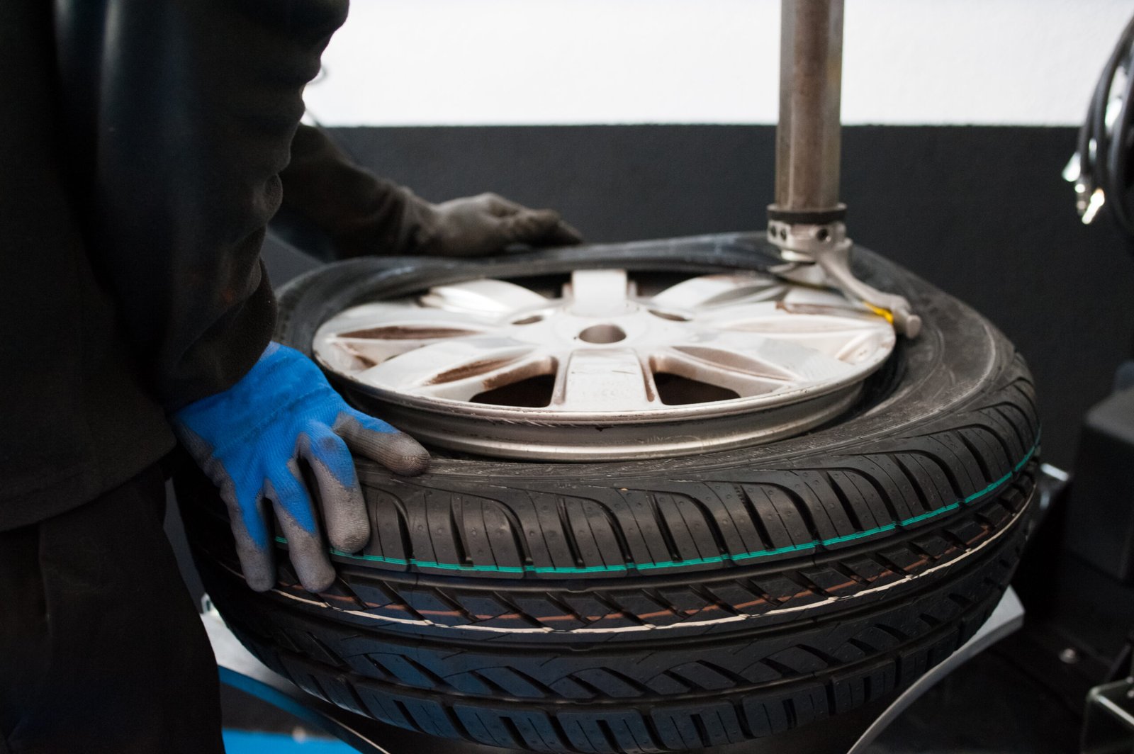 midsection-mechanic-holding-tire-garage